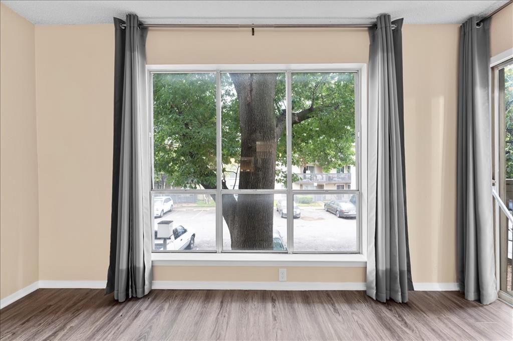 4859 Cedar Springs Road, Unit 241 Dallas, TX 75219 - Photo 5 of 38 a view of a room that has a large window and wooden floor