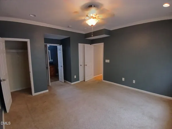 a view of empty room with a chandelier fan and a window
