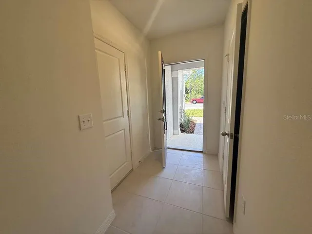 a view of a hallway with wooden floor and a bathroom