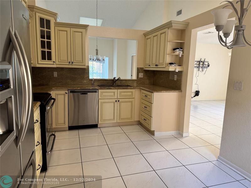 3727 Southwest Whispering Sound Drive Palm City, FL 34990 - Photo 28 of 29 a kitchen with stainless steel appliances a refrigerator sink and cabinets