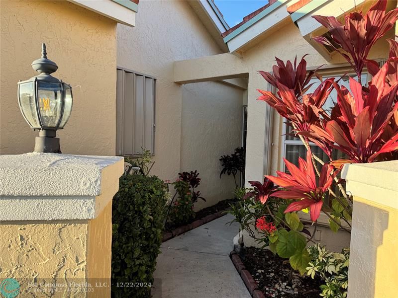 3727 Southwest Whispering Sound Drive Palm City, FL 34990 - Photo 3 of 29 a potted plant sitting in front of a house