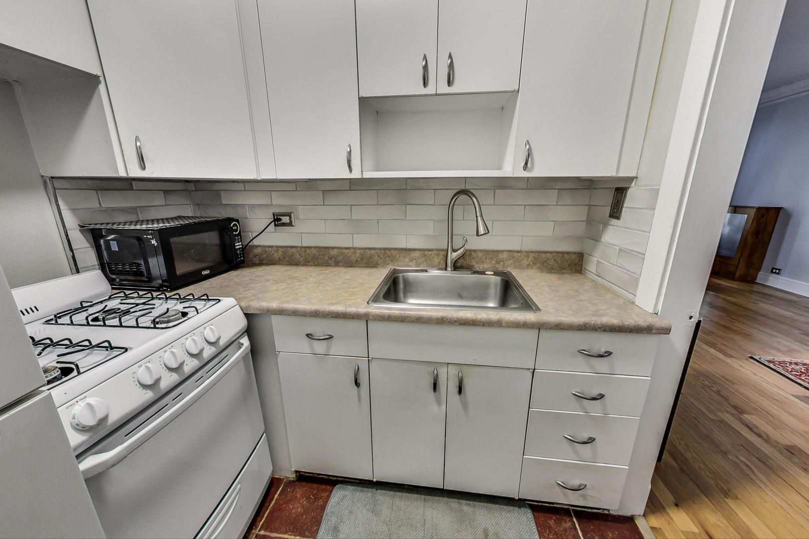 6101 North Sheridan Road, Unit 6H Chicago, IL 60660 - Photo 14 of 29 a kitchen with a sink stove and cabinets