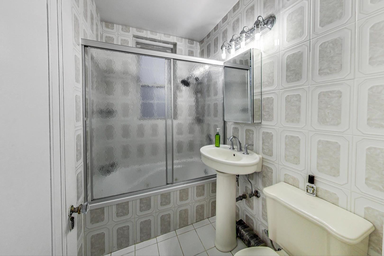 6101 North Sheridan Road, Unit 6H Chicago, IL 60660 - Photo 19 of 29 a bathroom with a sink toilet and shower