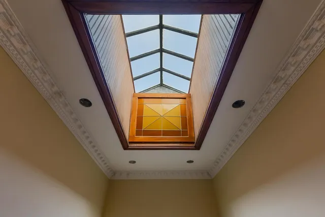 an empty room with wooden floor fireplace and windows