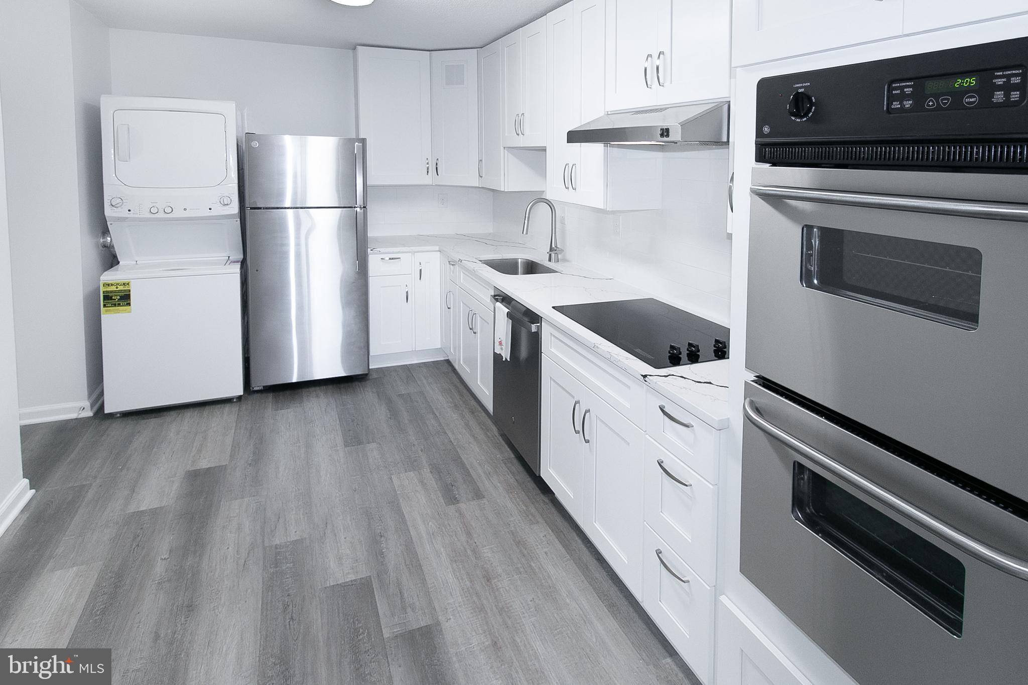 a kitchen with white cabinets and white appliances