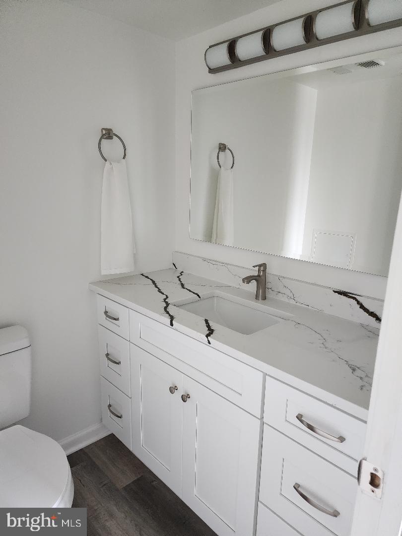 307 Yoakum Parkway, Unit 1024 Alexandria, VA 22304 - Photo 25 of 50 a bathroom with a toilet sink and mirror