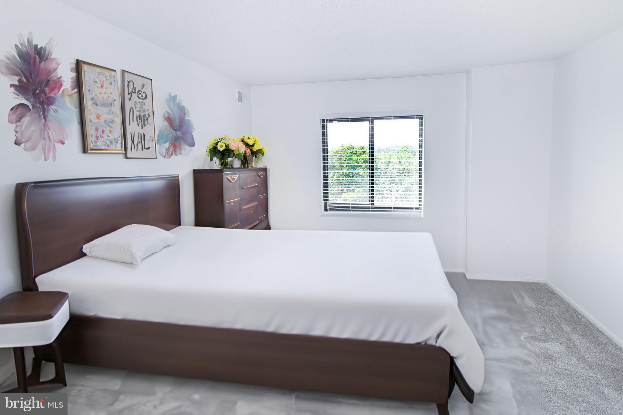 307 Yoakum Parkway, Unit 1024 Alexandria, VA 22304 - Photo 29 of 50 a bedroom with a bed potted plant and a window