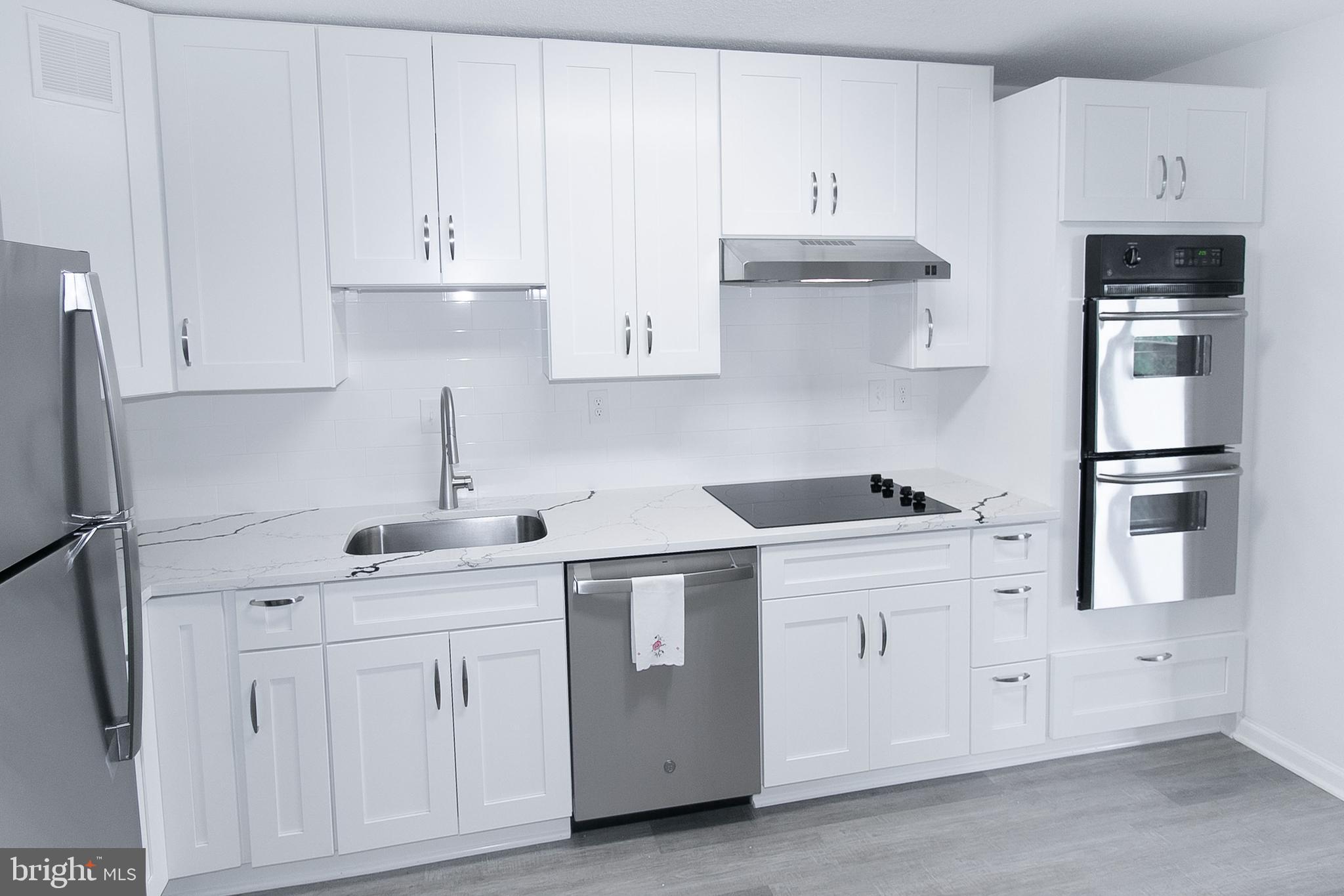 307 Yoakum Parkway, Unit 1024 Alexandria, VA 22304 - Photo 7 of 50 a kitchen with white cabinets and white appliances