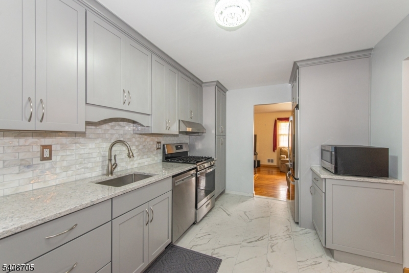 4 George Street Succasunna, NJ 07876 - Photo 2 of 34 a kitchen with stainless steel appliances granite countertop a sink and a refrigerator