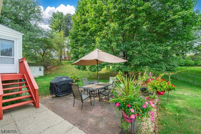 4 George Street Succasunna, NJ 07876 - Photo 28 of 34 a backyard of a house with table and chairs under an umbrella