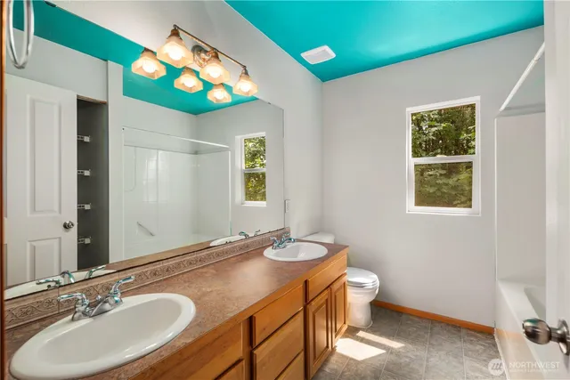 a bathroom with a sink vanity mirror and toilet