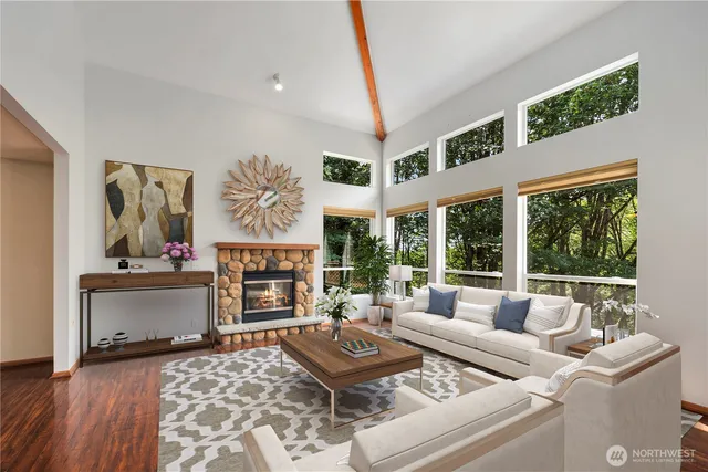 a living room with furniture a fireplace and a large window