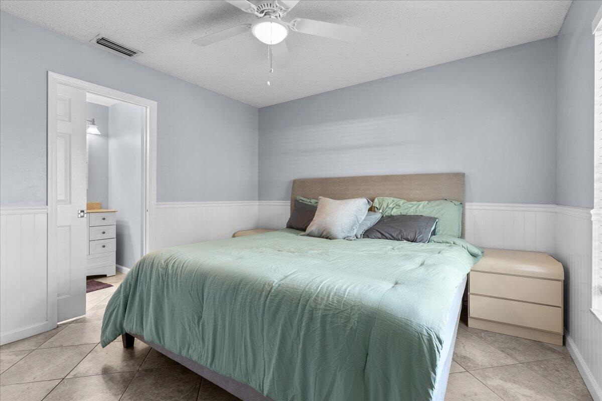 4243 Southwest Utterback Street Port St. Lucie, FL 34953 - Photo 11 of 28 a bedroom with a bed and a chandelier