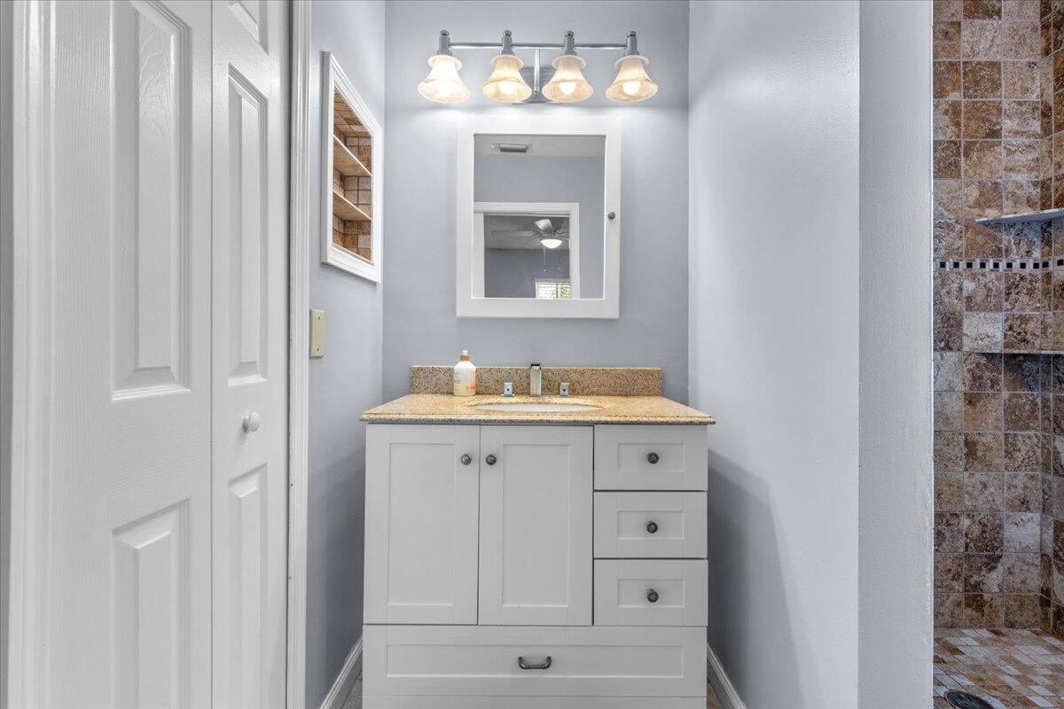 4243 Southwest Utterback Street Port St. Lucie, FL 34953 - Photo 12 of 28 a bathroom with a sink and a mirror