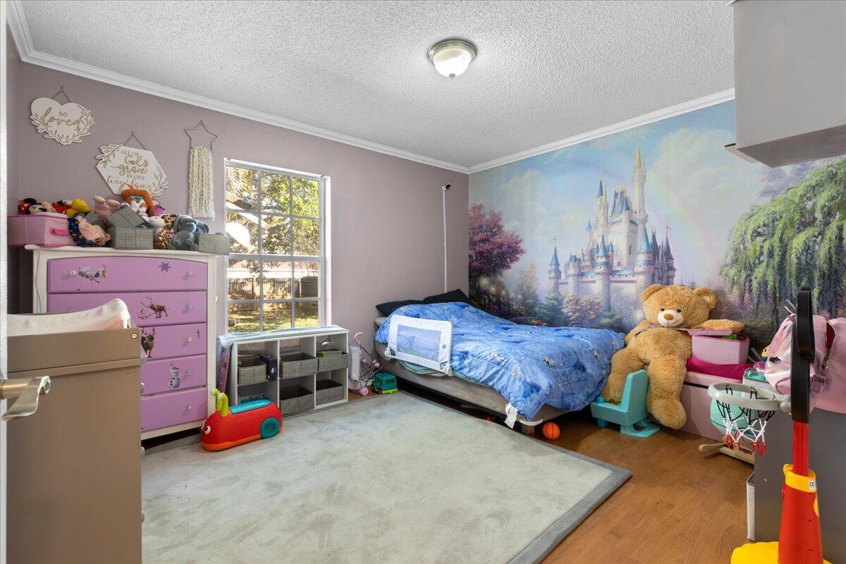 4243 Southwest Utterback Street Port St. Lucie, FL 34953 - Photo 21 of 28 a bedroom with furniture and a window