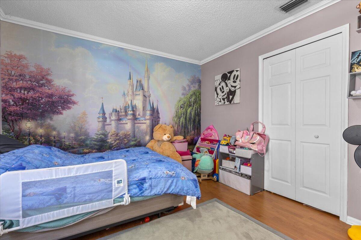 4243 Southwest Utterback Street Port St. Lucie, FL 34953 - Photo 22 of 28 a bedroom with a bed and a window