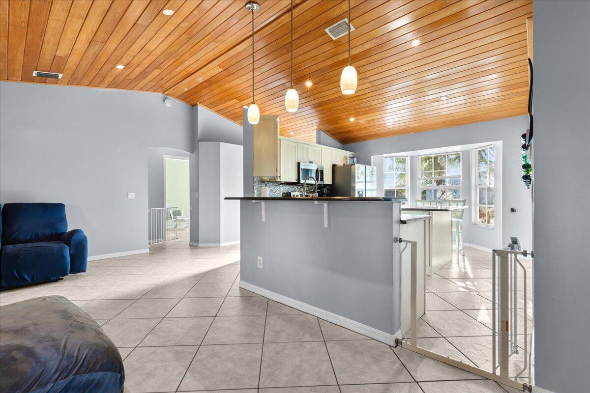 4243 Southwest Utterback Street Port St. Lucie, FL 34953 - Photo 6 of 28 a kitchen with stainless steel appliances granite countertop a refrigerator and a sink