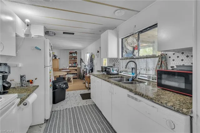 a large kitchen with a lot of counter space and wooden floor
