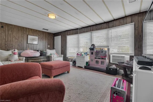 a living room with furniture a flat screen tv and a window