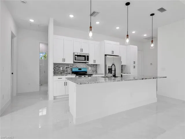 a kitchen with kitchen island a white counter top oven and cabinets