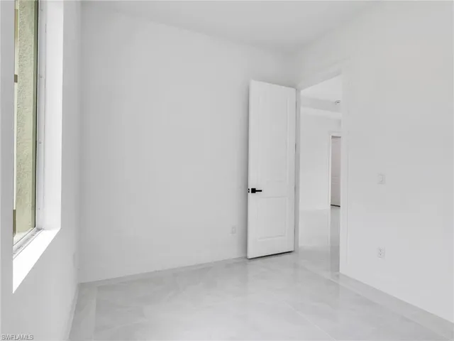 an empty room with a window and ceiling fan