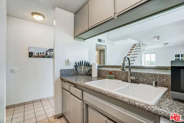 a bathroom with a granite countertop sink and a mirror