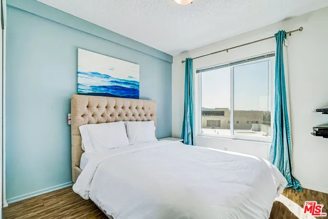 a large bed sitting in a bedroom next to a window