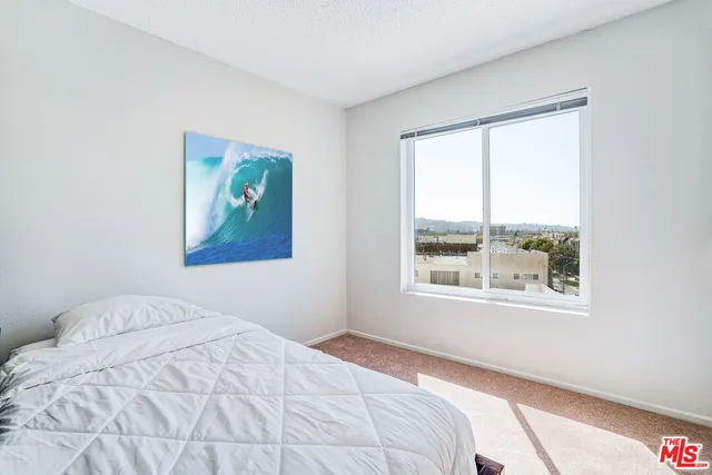 a bedroom with a bed and a painting on the wall