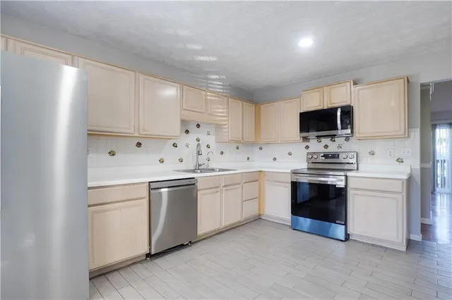 a kitchen with granite countertop white cabinets and stainless steel appliances
