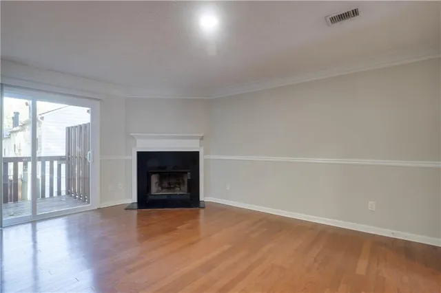 wooden floor fireplace and windows in an empty room