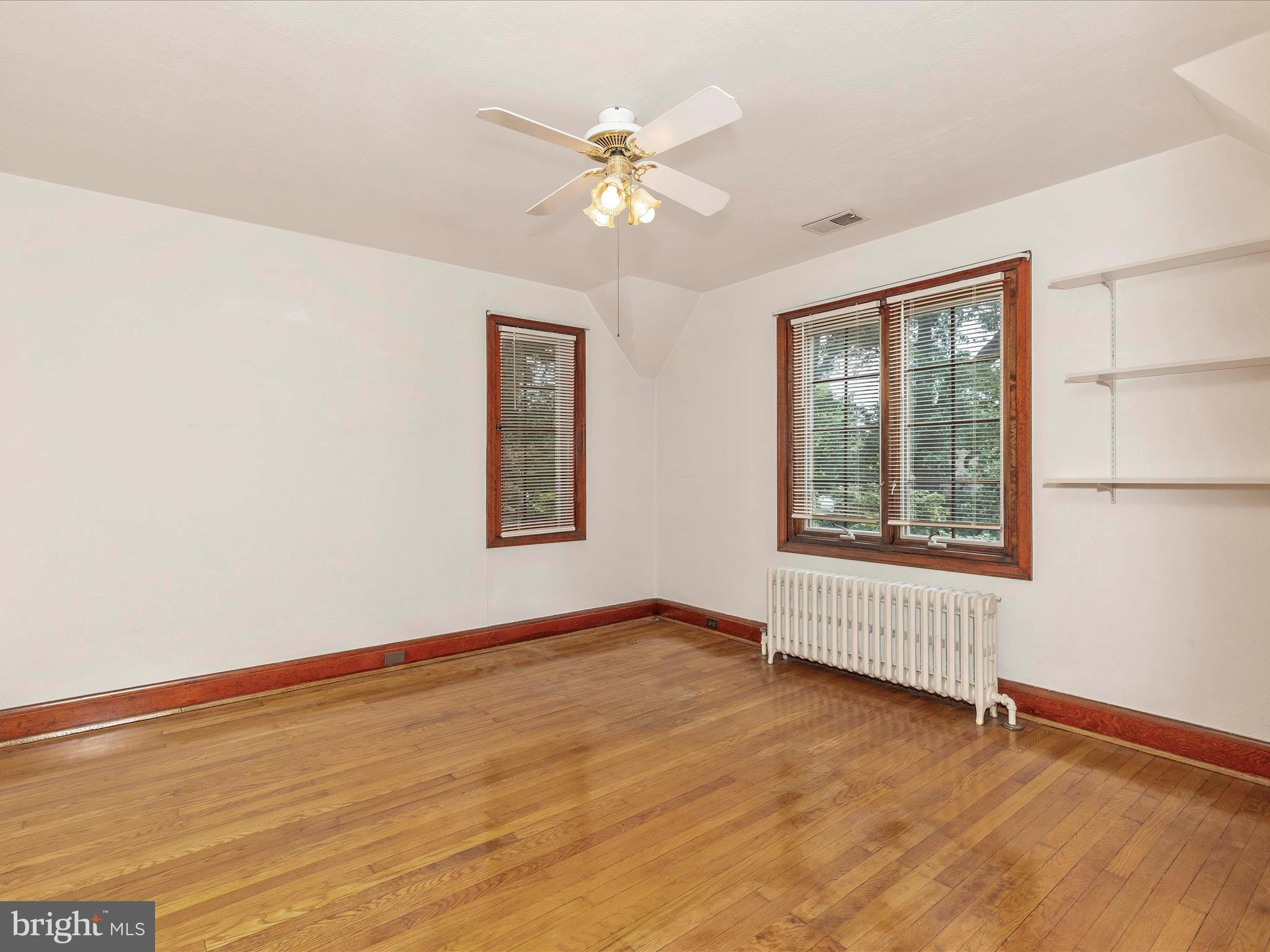 5100 Brook Green Road Baltimore, MD 21229 - Photo 30 of 54 an empty room with wooden floor chandelier fan and windows
