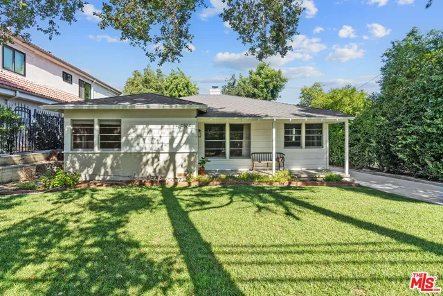 a view of a house with backyard sitting area and garden