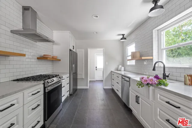 a kitchen with granite countertop kitchen island white cabinets and stainless steel appliances