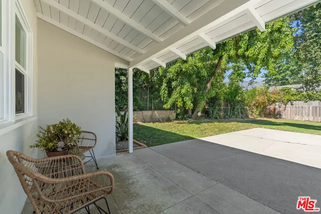 a view of patio with table and chairs and potted plants