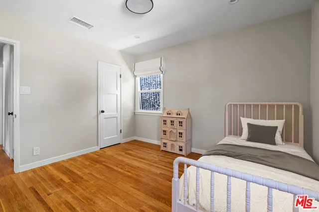 a bedroom with a bed and wooden floor