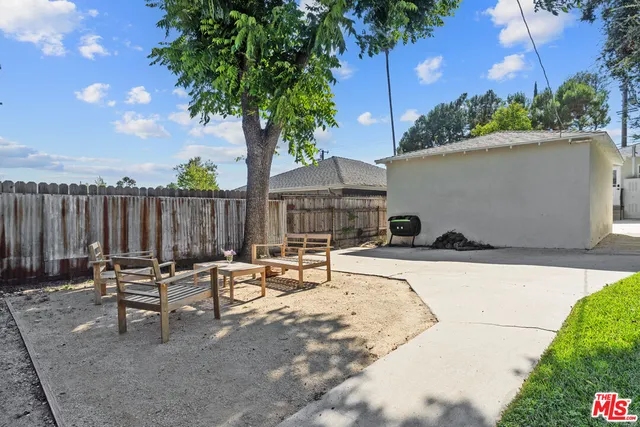 a backyard of a house with table and chairs
