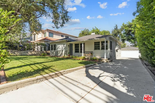 a front view of a house with yard and green space