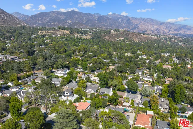a view of a lush green field with mountains in the background