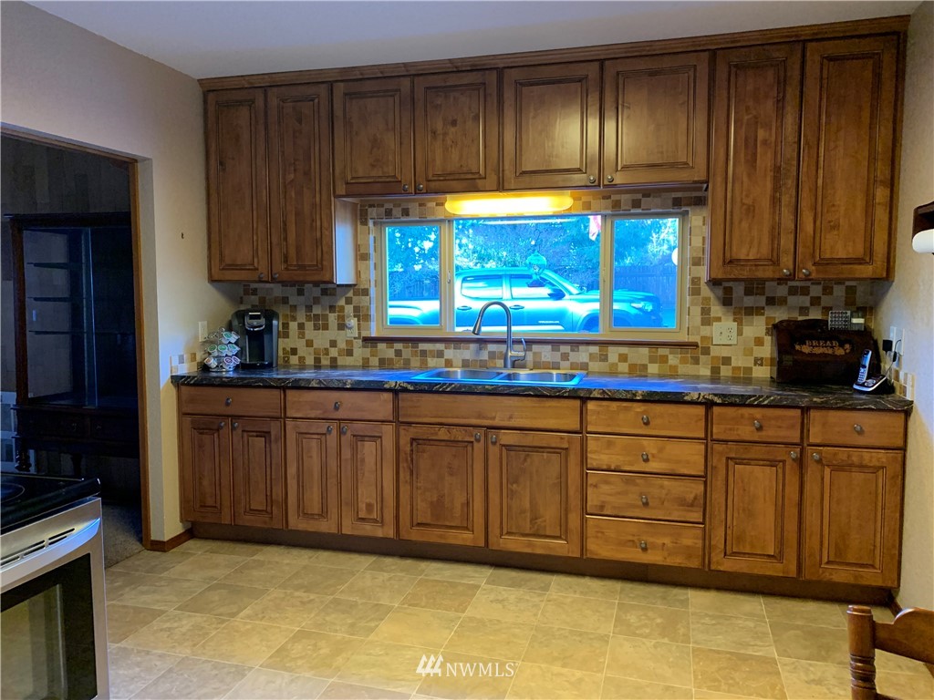 106 Pattee Road Chehalis, WA 98532 - Photo 6 of 33 a kitchen with granite countertop wooden cabinets a sink and dishwasher