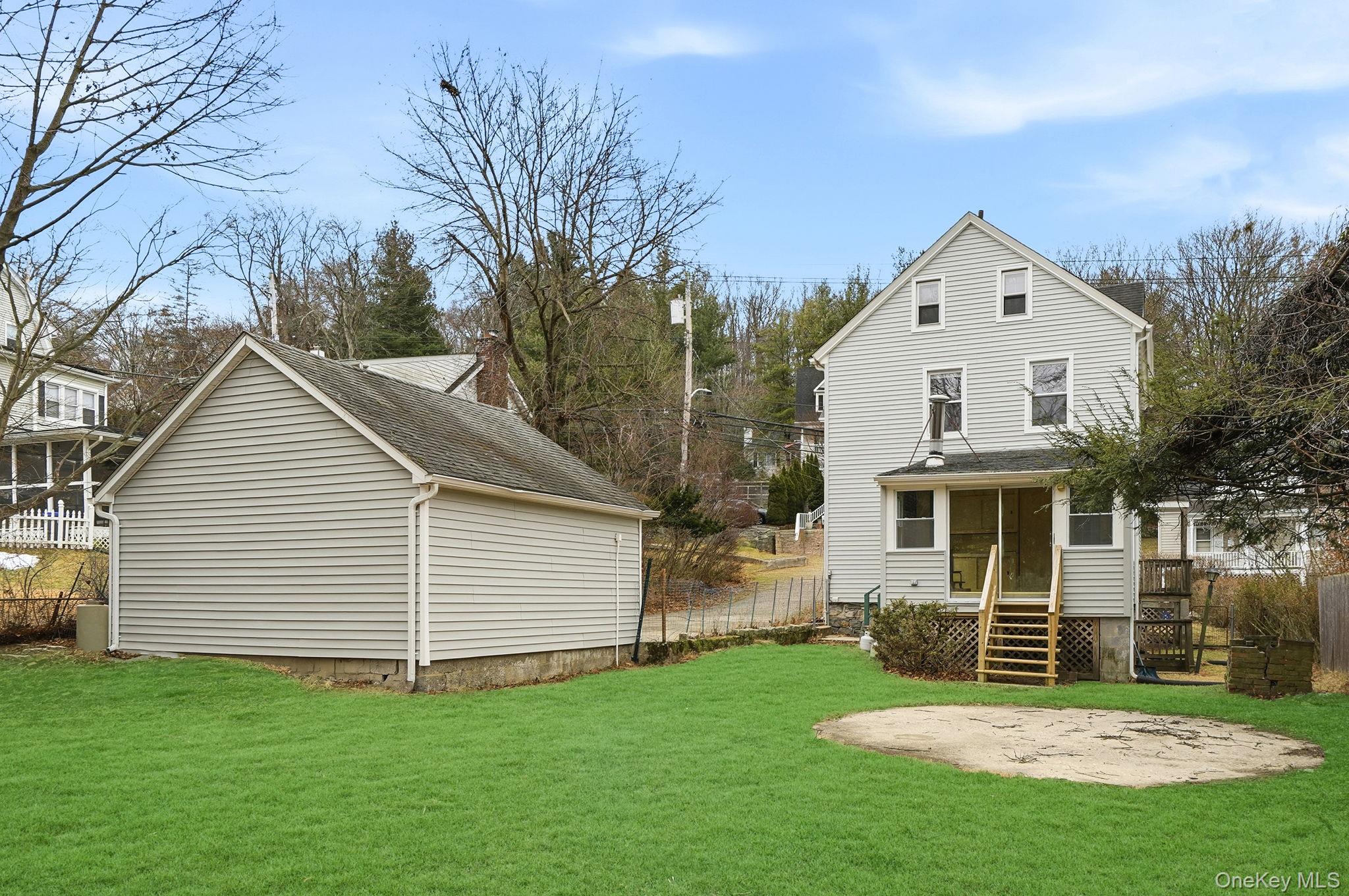 33 Mountain Road Irvington, NY 10533 - Photo 34 of 38 Backyard with concrete patio and back of 2 car garage