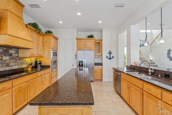 a large kitchen with stainless steel appliances granite countertop a sink and cabinets