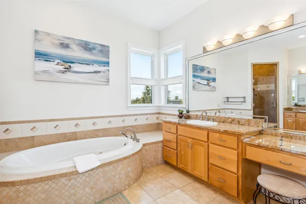 a bathroom with a tub a sink and mirror