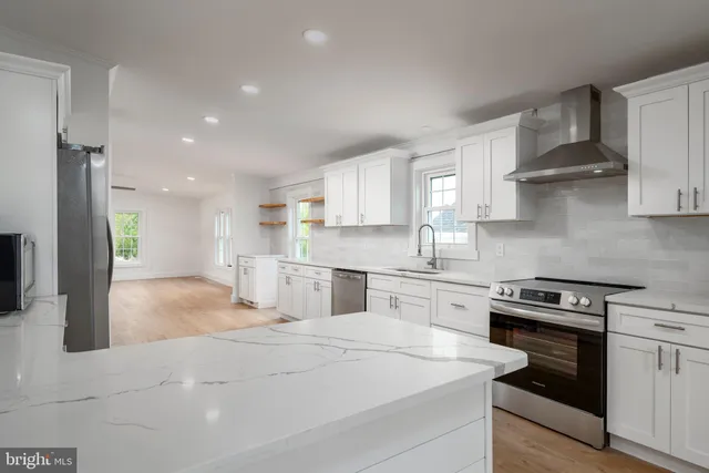 a kitchen with stainless steel appliances granite countertop a stove a sink and a refrigerator