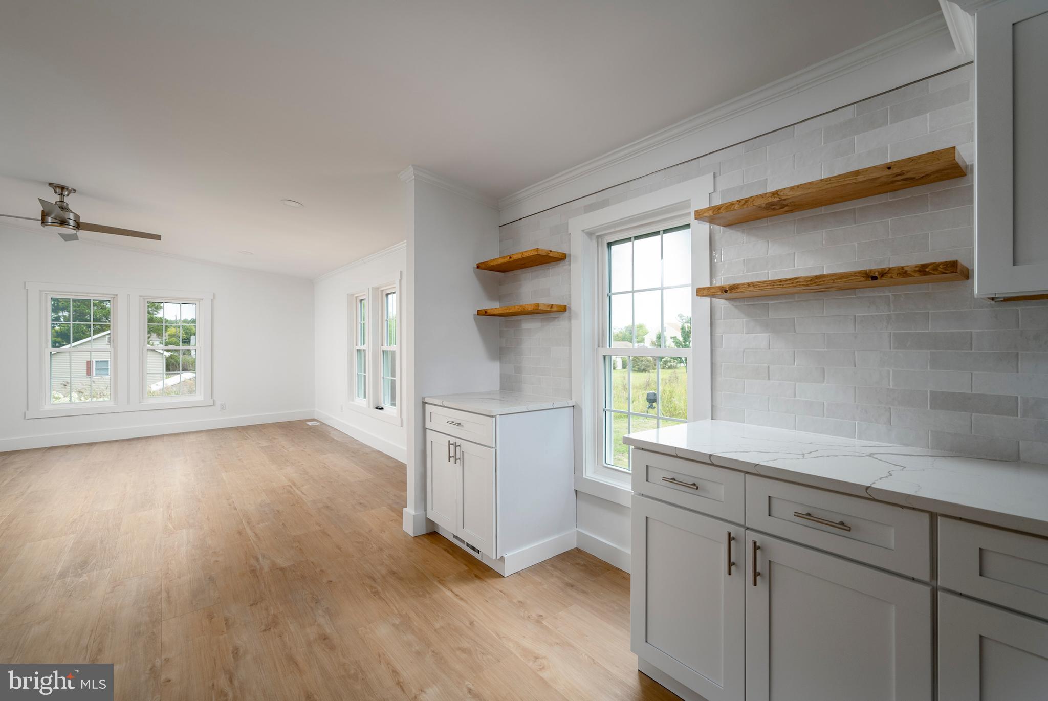 12403 Salisbury Road Ocean City, MD 21842 - Photo 15 of 28 a kitchen with white cabinets and wooden floors