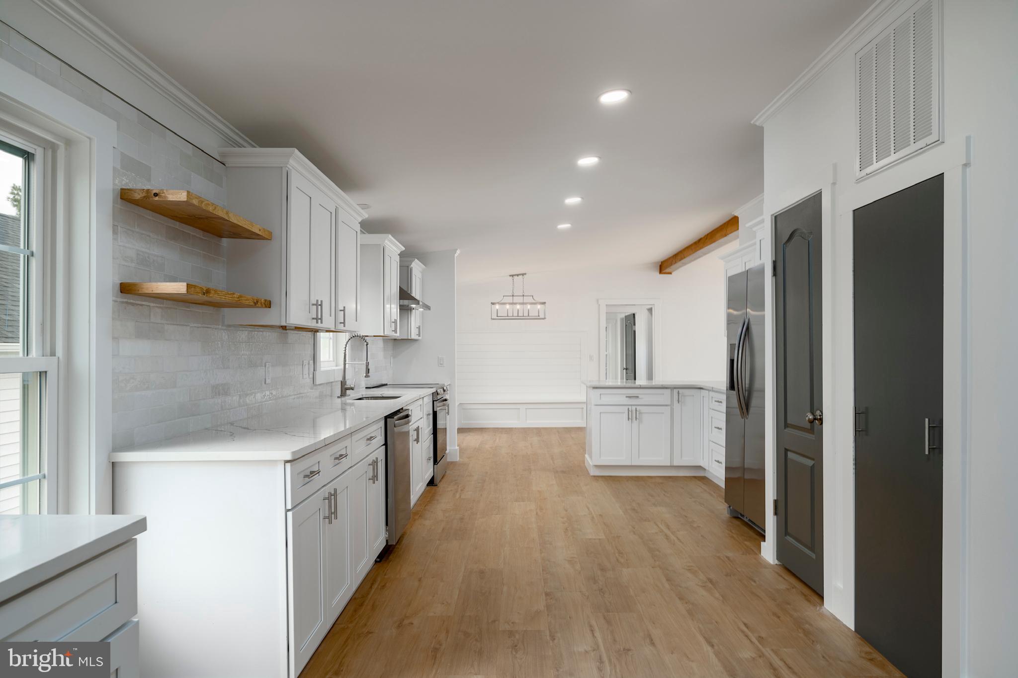 12403 Salisbury Road Ocean City, MD 21842 - Photo 19 of 28 a large kitchen with stainless steel appliances lots of counter space and wooden floor