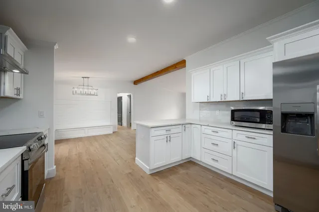 a kitchen with granite countertop white cabinets and wooden floor