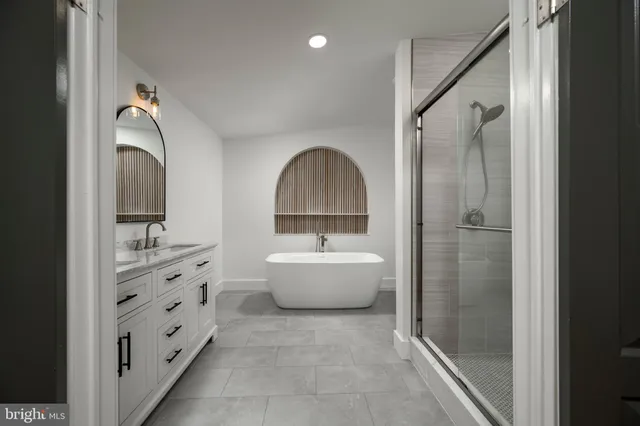a bathroom with a bathtub sink mirror and toilet