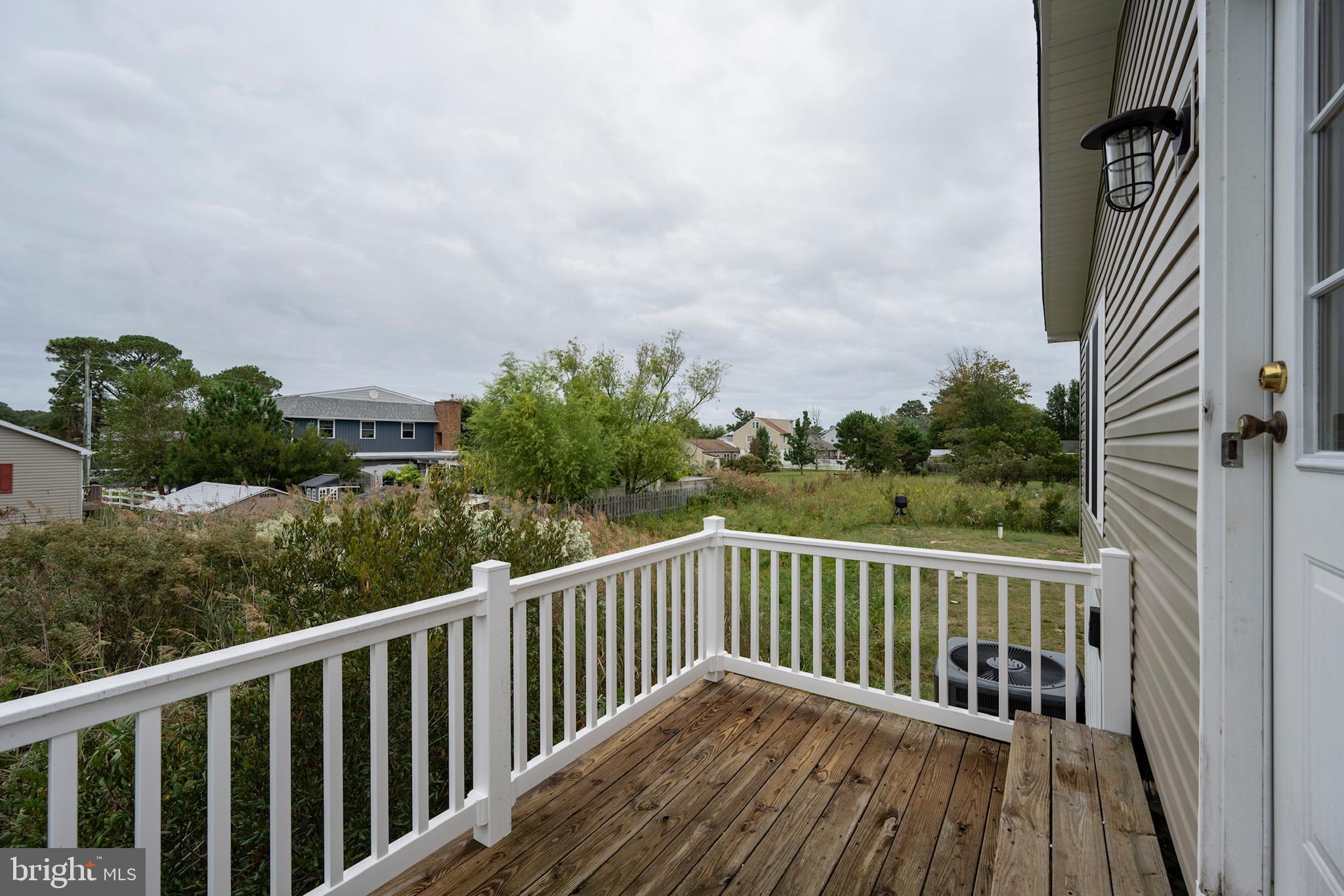 12403 Salisbury Road Ocean City, MD 21842 - Photo 6 of 28 a balcony with wooden floor and fence
