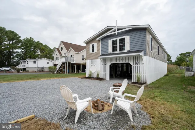 a front view of a house with a yard fire pit and outdoor seating