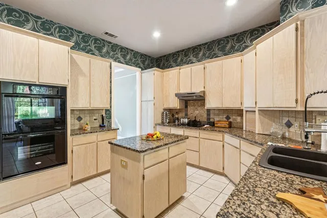 a kitchen with a sink stove and white cabinets